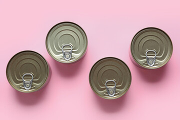 Tin cans with fish on pink background