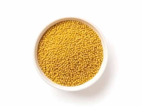 A bowl of yellow mustard seeds on a white background