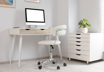 Stylish office interior with comfortable chair, desk and computer