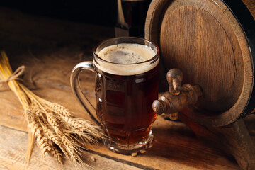 Wooden barrel and mug of cold beer on table