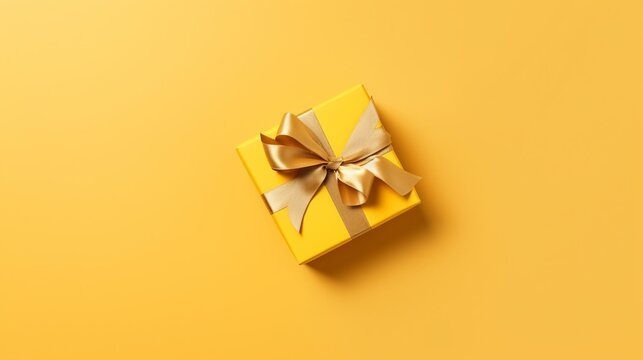 Golden ribbon gift box on yellow background, copy space, birthday/Christmas present, flat lay, top view concept. generative ai