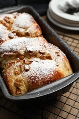Delicious yeast dough cake in baking pan on wooden table, closeup