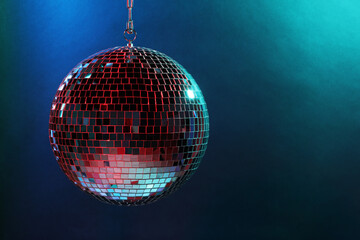 Shiny disco ball under blue lights, space for text