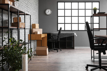 Workplace with cardboard boxes in office on moving day