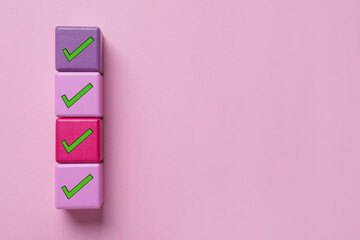 Cubes with check marks on pink background, top view. Space for text