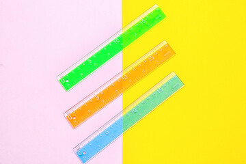 Colorful plastic rulers on color background