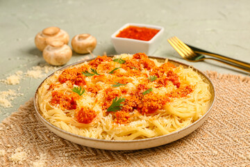 Plate of tasty Italian pasta with Parmesan cheese on light background