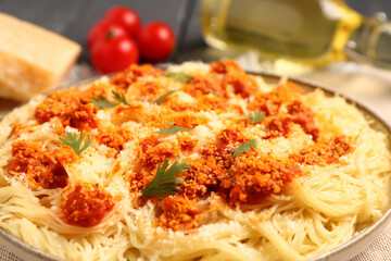Plate of tasty Italian pasta with Parmesan cheese on table, closeup