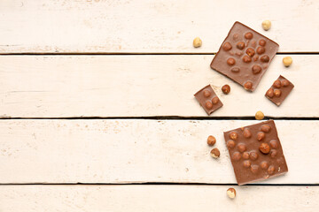 Sweet tasty chocolate with nuts on  light wooden background