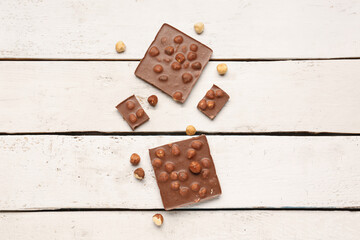 Sweet tasty chocolate with nuts on  light wooden background
