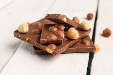 Sweet tasty chocolate with nuts on  light wooden background