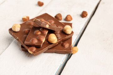 Sweet tasty chocolate with nuts on  light wooden background