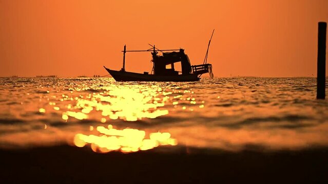 Traditional fishing boats anchored in the sea during sunset.