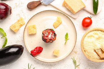 Plate with tasty baked Eggplant Parmesan and ingredients on light background