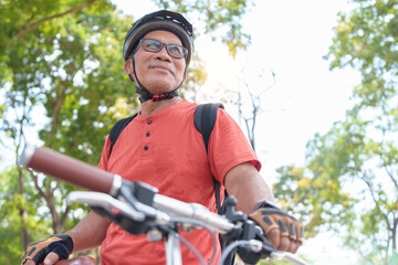Active Asian Chinese Senior man travel with bicycle in a park outdoors. Retirement activity, Relax,...
