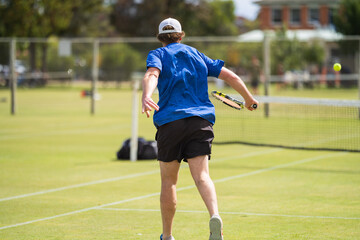 Amateur playing tennis at a tournament and match on grass in Europe 