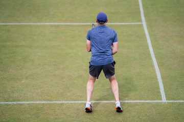 Amateur playing tennis at a tournament and match on grass in Europe 