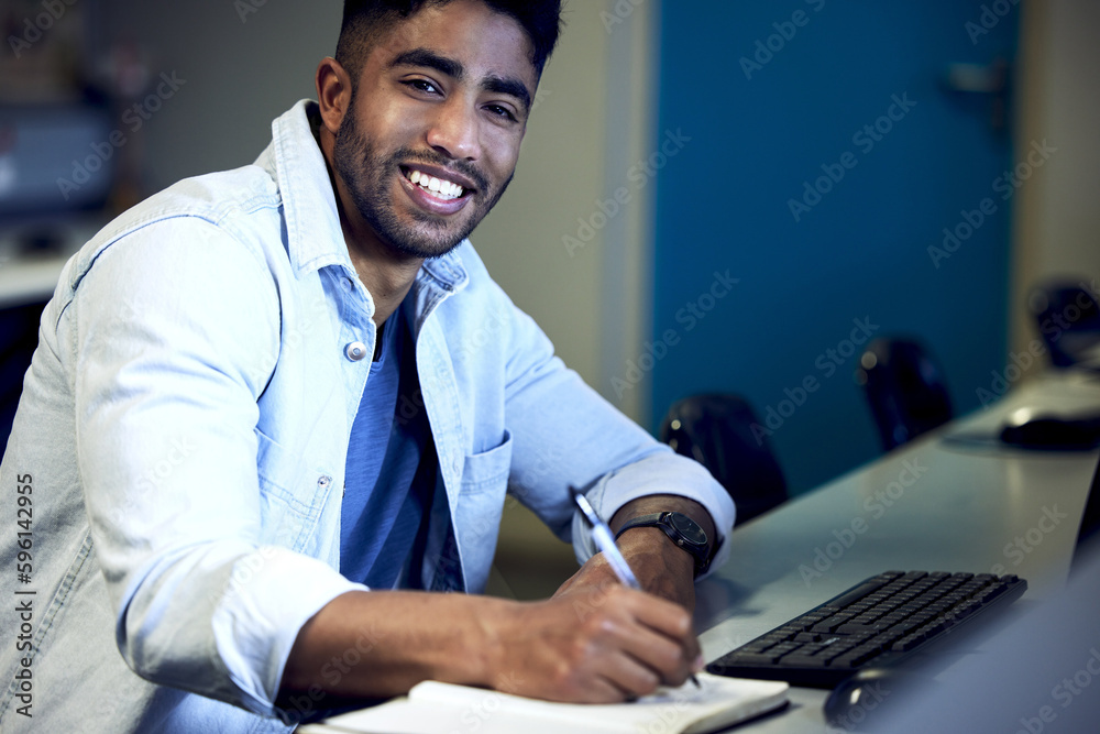 Leinwandbilder Learning the fine art of computer language. a young man writing in a notebook and using a computer at college.