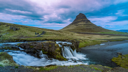 Kirkjufell mountain with Kirkjufellsfoss infront of it under morning sun light in Iceland