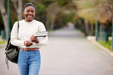 Fototapeta premium My future is calling and I must go. a young woman carrying her schoolbooks outside at college.