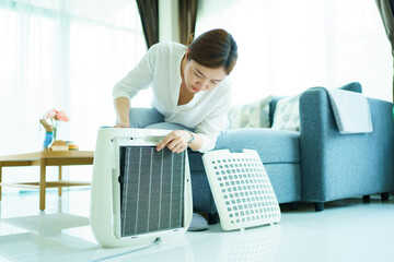 Asian woman changing the dirty air purifier filter after using for a long time in the dirty air...