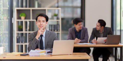 Asian Business person makes analysis and research financial report at office, analyzes profits. Accountant checks status of financial