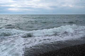 Black Sea on the Sochi coast and a pebble beach on a sunny day with clouds, Sochi, Krasnodar Territory, Russia
