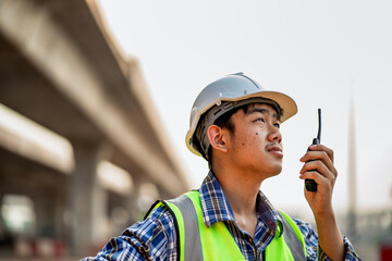 Civil engineers use radio communications to command work in the construction site.