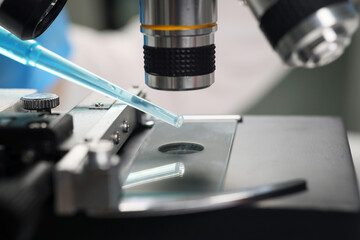 Fototapeta na wymiar Scientist examines blue reagent under electronic microscope