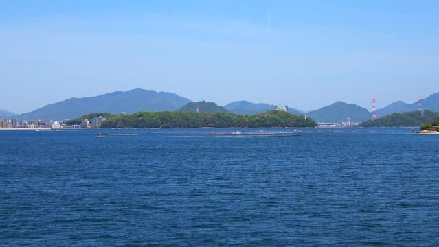 瀬戸内海に浮かぶ牡蠣養殖筏や宇品島などの島々、広島湾風景を船から移動撮影  4K  2023年4月23日