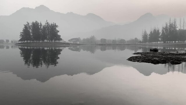 Reflection like a mirror in calm water lake Nature park mountain landscape in morning sky on black and white tone 