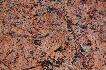 Close-up beautiful abstract red marble background with dark spots.