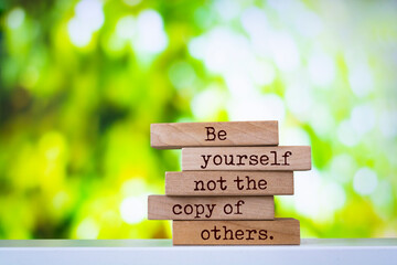 Wooden blocks with words 'Be Yourself Not The Copy Of Others'.