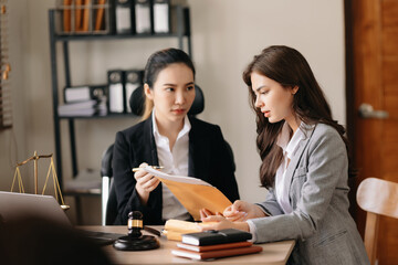 Asian business team and lawyers discussing contract papers sitting at the table. Concepts of law, advice, legal services. at office