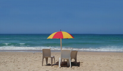 beach chairs and umbrella on the beach against clear blue sky with space for text