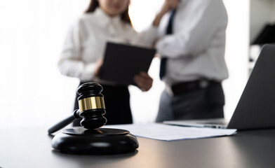 Focus closeup wooden gavel on blur background of lawyer colleagues or drafting legal documents on...
