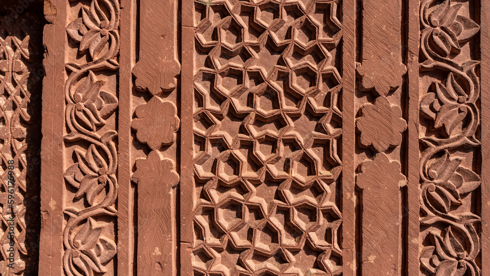 Wall mural details of ancient indian architecture. relief patterns and floral ornaments are carved on the sands