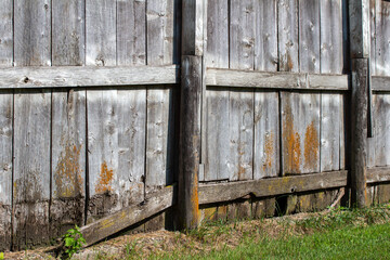 Close up texture background of an old weathered wooden fence wall, showing exposed gray wood grain