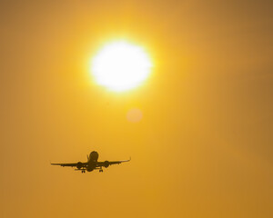 Bottom view of a flying plane at sunset. 