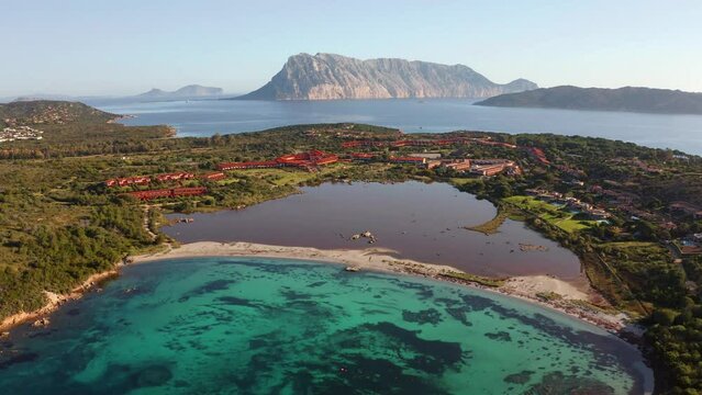4k drone flight moving to the side footage (Ultra High Definition) of Salina Bamba beach with Tavolara mountain on background. Wonderful morning scene of Sardinia island, Italy, Europe.