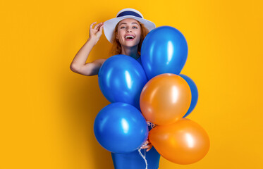 Fototapeta na wymiar glad woman with balloons at summer birthday in studio. woman with balloons at summer birthday