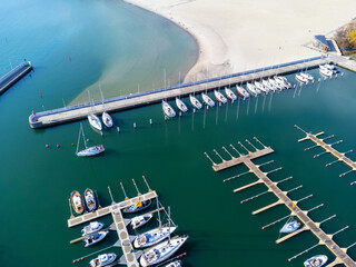 Aerial view of the many white yachts and sailboats moored in the marina on the turquoise water, summer season. Harbor in Poland Gdynia.
