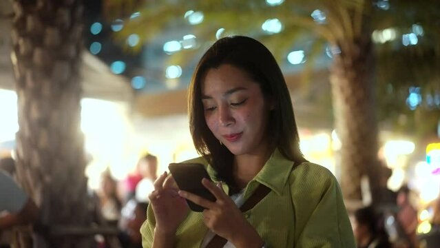 Solo Traveler Asian Women Enjoy Buying And Eating Traditional Street Food Night Market Take Photo Upload Social Media. Beautiful Tourists Woman Feeling Happy Buying Street Food In The Evening.