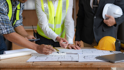 Architect or engineer are designing house, modifying plan, creating construction project and...