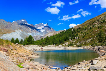 View of Grunsee lake (Green Lake) and the Swiss Alps at summer on the Five Lakes Trail in Zermatt, Switzerland