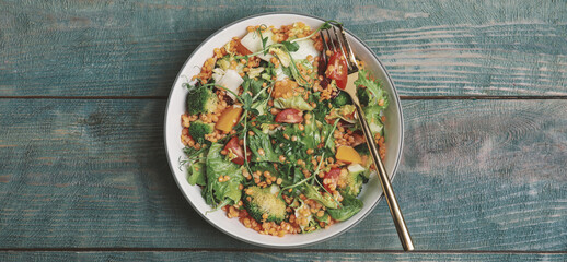 Delicious salad with lentils and vegetables served on light blue wooden table, top view. Banner design
