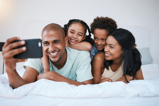 Selfie, family and smile in home bedroom, bonding and relaxing or lying together. Bed, photo and children with mother and father taking pictures for happy memory, social media or profile picture.