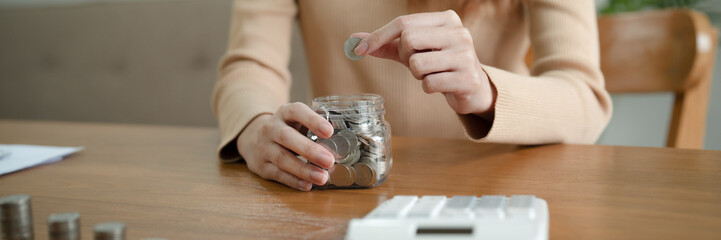 Growing savings concept. Saving money by hand putting coins money banknotes in jug glass financial accounting planning