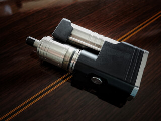 Advanced personal vaporizer or e-cigarette Vintage style, side by side style, on the rosewood back...