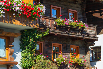 Fototapeta na wymiar Flowering balconies on houses in the alps